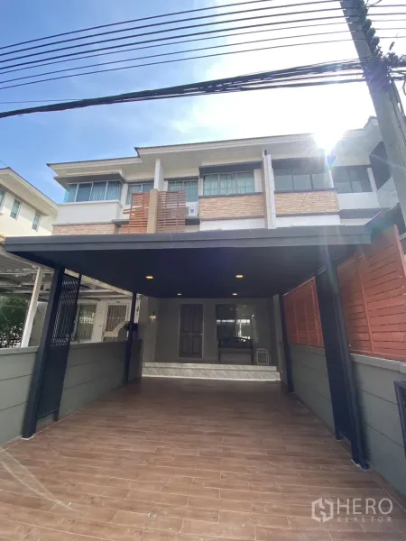 Townhouse for rent in Bang Kapi, Bangkok - Modern two-storey townhouse facade with covered carport and wood accents in Bang Kapi, Bangkok.