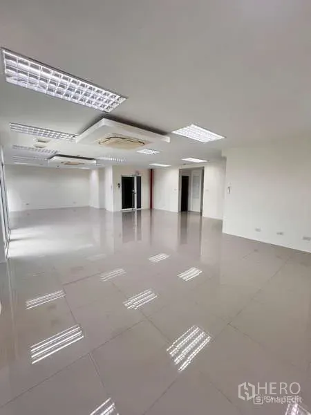 Office Space for rent in Chatuchak, Bangkok - Spacious unfurnished office floor with white walls, ceiling lights, multiple doorways, and reflective tiled flooring near MRT Lat Phrao.