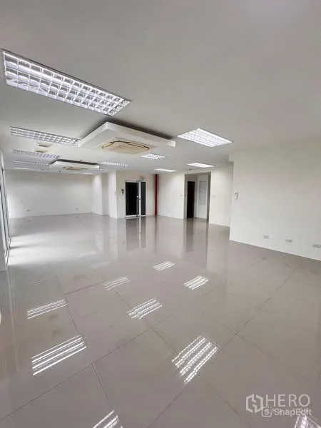 Office Space for rent in Chatuchak, Bangkok - Spacious unfurnished office floor with white walls, ceiling lights, multiple doorways, and reflective tiled flooring near MRT Lat Phrao.
