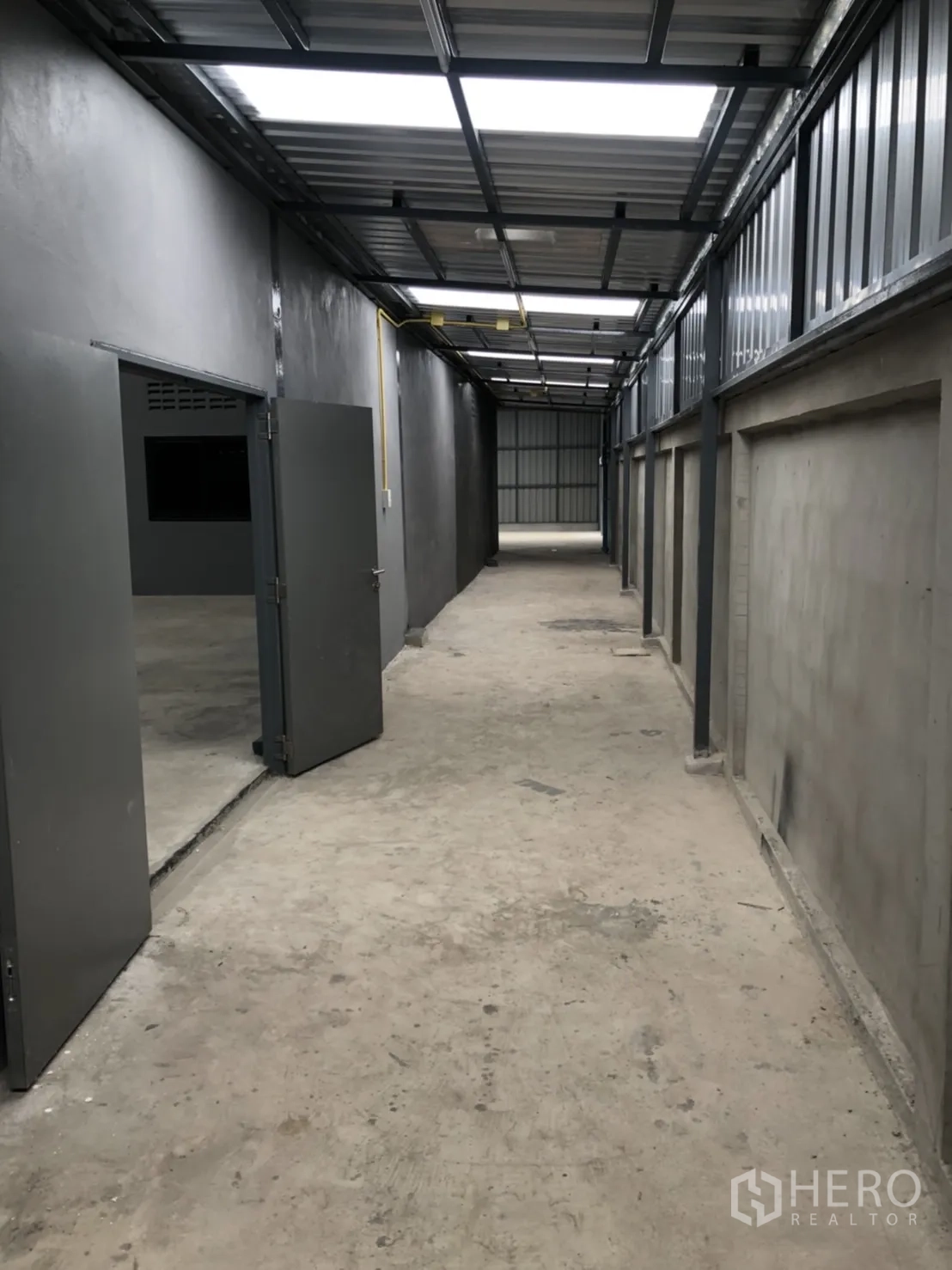 คลังสินค้า ให้เช่าในLam Luk Ka, Pathum Thani - ทางเดินยาวมุงหลังคา มีประตูเปิดสู่ห้องเก็บของและช่องแสงด้านบน