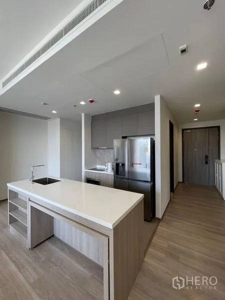 Condominium for rent in Bang Kho Laem, Bangkok - Open-plan kitchen with island, entry corridor, and built-in appliances.