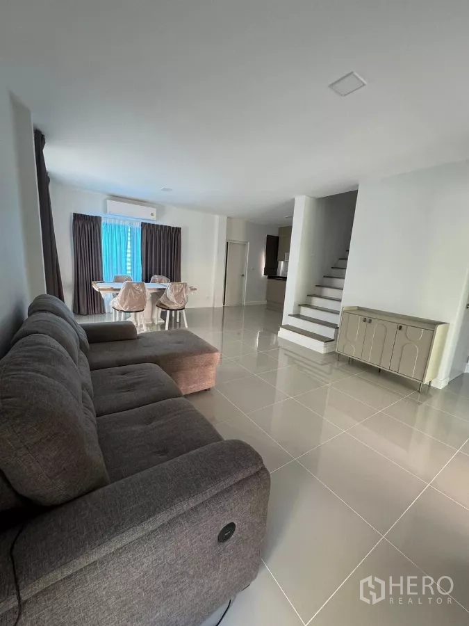Detached House for rent in Bang Phli, Samut Prakan - Spacious lounge with glossy floor tiles and staircase beside the dining area.