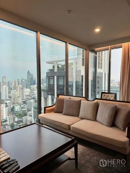 Condominium for rent in Watthana, Bangkok - Cozy sofa set by wraparound windows offering a panoramic high-floor city view.
