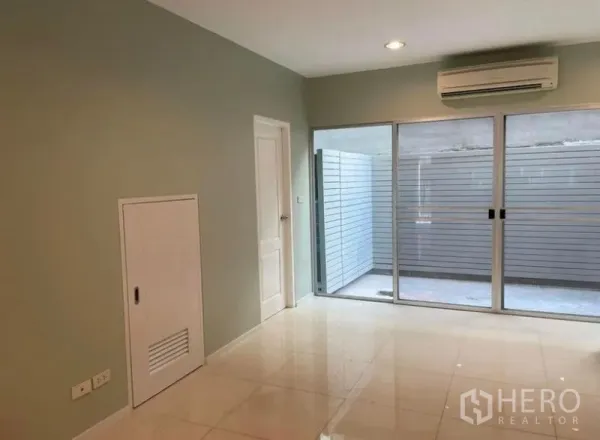 ทาวน์เฮาส์ ให้เช่าในSuan Luang, Bangkok - ห้องนั่งเล่นติดแอร์ พื้นกระเบื้องเงา พร้อมประตูกระจกบานเลื่อนเปิดสู่ลานส่วนตัว