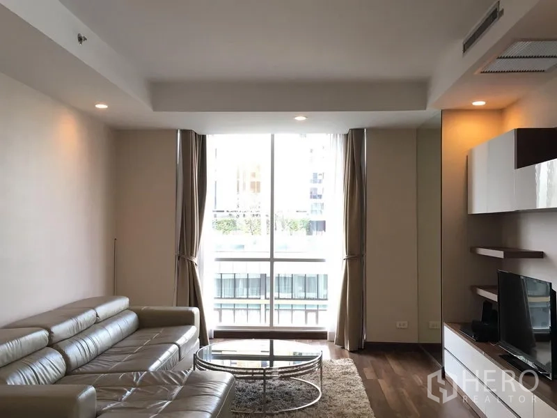 คอนโด ให้เช่าในPathum Wan, Bangkok - ห้องนั่งเล่นสไตล์โมเดิร์น โซฟาหนัง ชุดทีวี และหน้าต่างสูงจรดเพดาน