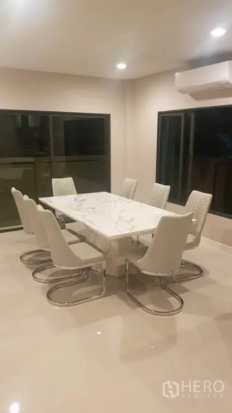 独立式住宅 出租在Saphan Sung, Bangkok - 餐区设大理石餐桌与八把软垫椅，筒灯与大窗采光。