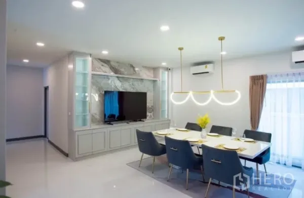 Detached House for rent in Bang Phli, Samut Prakan - Open-plan dining area with chandelier, built-in TV wall and display cabinetry.