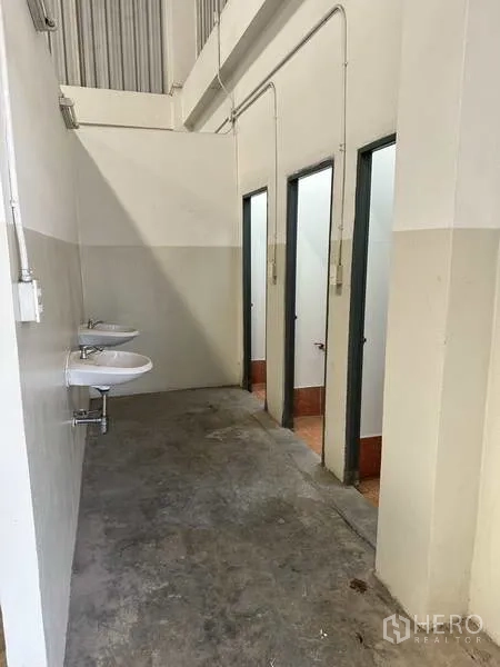 โรงงาน ให้เช่า - โซนห้องน้ำโรงงาน มีห้องสุขาหลายห้องและอ่างล้างมือแขวนผนัง