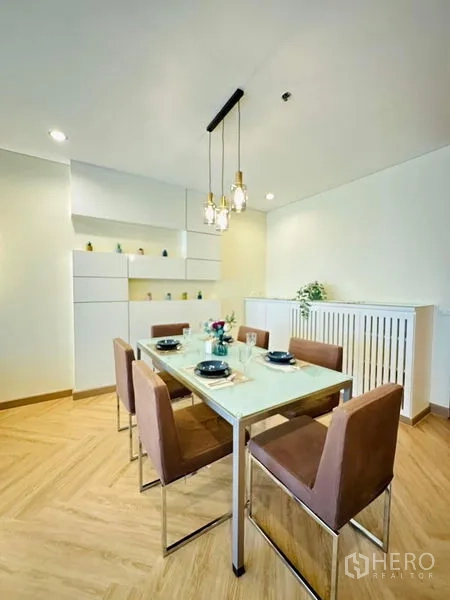 公寓 出租在Bang Rak, Bangkok - 餐区可容纳六人，吊灯与嵌入式储物柜。