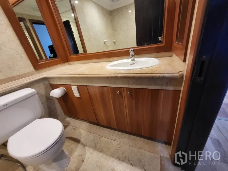 คอนโด ให้เช่าในPathum Wan, Bangkok - ห้องน้ำ เคาน์เตอร์หินยาว กระจกกรอบไม้ และโถสุขภัณฑ์บนพื้นกระเบื้อง