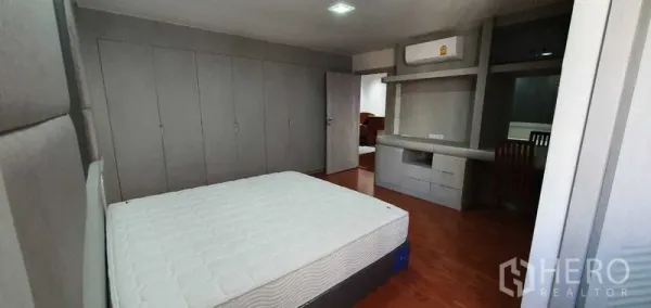 คอนโด ให้เช่าในKhlong Toei, Bangkok - ห้องนอนกว้างพร้อมตู้เสื้อผ้าบิลท์อินสีเทาและมุมทำงาน