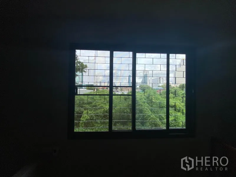 Retail Space for rent in Khlong San, Bangkok - City and greenery view through large grilled window.