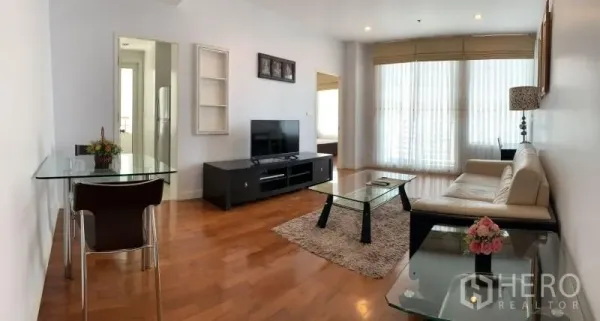 คอนโด ให้เช่าในKhlong Toei, Bangkok - ห้องนั่งเล่นสว่างพร้อมหน้าต่างบานใหญ่ โซฟาสีครีม โต๊ะกระจก และพื้นไม้