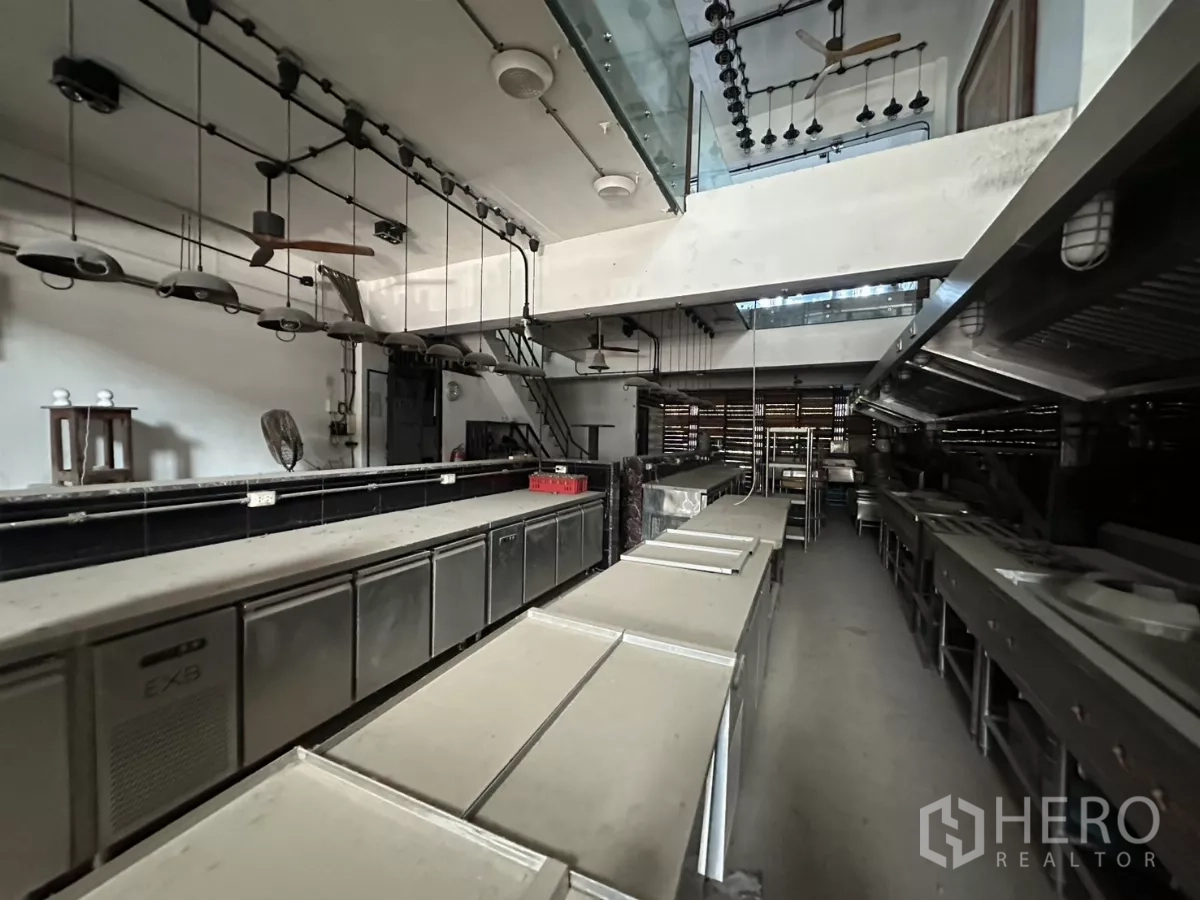店屋 出租在Bang Na, Bangkok - 开放式厨房区，悬挂照明、备餐台与全套排风系统。
