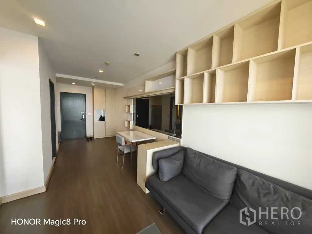 คอนโด for rent in Watthana, Bangkok - มุมมองอีกด้านของห้องนั่งเล่นพร้อมชั้นบิลท์อิน มุมทานอาหาร และโถงทางเข้า