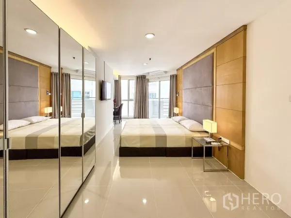 คอนโด ให้เช่าในKhlong Toei, Bangkok - ห้องนอนมาสเตอร์สว่าง ตู้เสื้อผ้าบานกระจก ผนังหัวเตียงบุ และประตูกระจกออกสู่ระเบียง