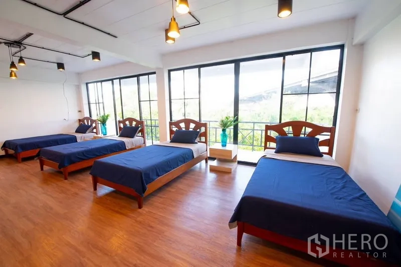 带办公室的家 出租或出售在Phra Khanong, Bangkok - 大开间宿舍式卧室，四张单人床与通高窗。