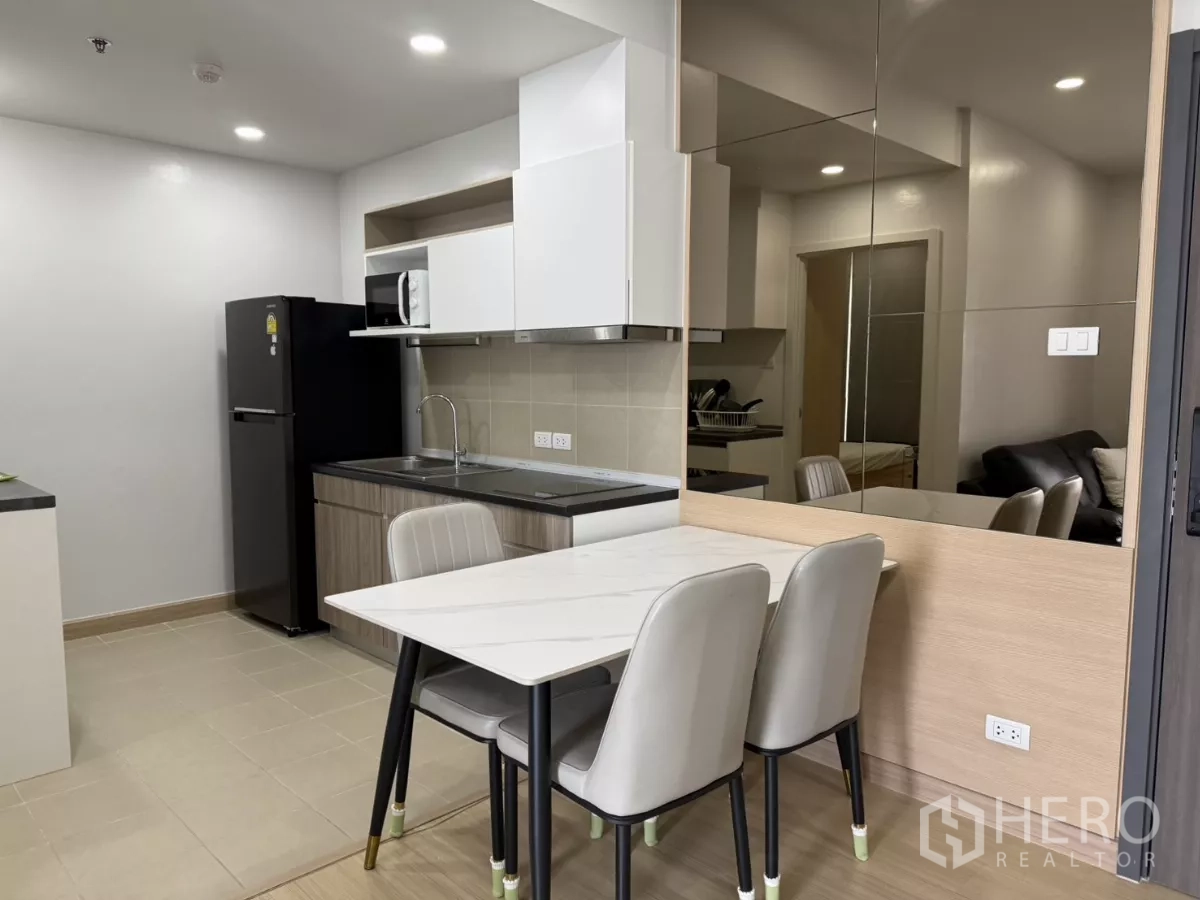 คอนโด ให้เช่าในKhlong Toei, Bangkok - มุมรับประทานอาหารโต๊ะสีขาวสองที่นั่ง ข้างผนังกระจกติดกับครัว