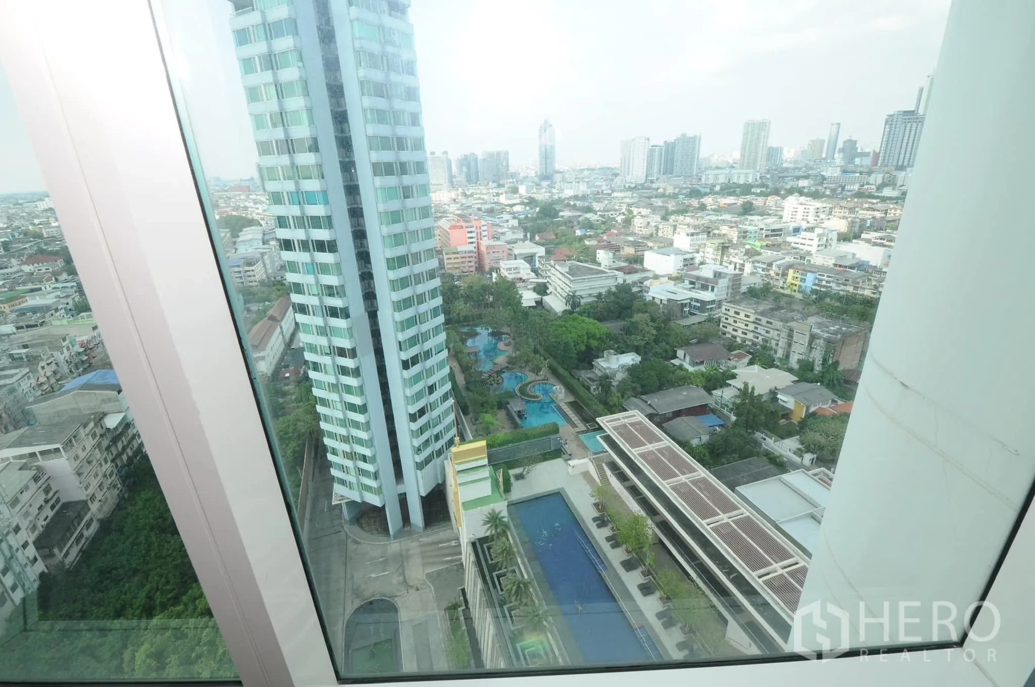 คอนโด ขายในKhlong San, Bangkok - มุมมองจากชั้นสูงเห็นสระว่ายน้ำหลายสระและสวนภูมิทัศน์ของโครงการ.