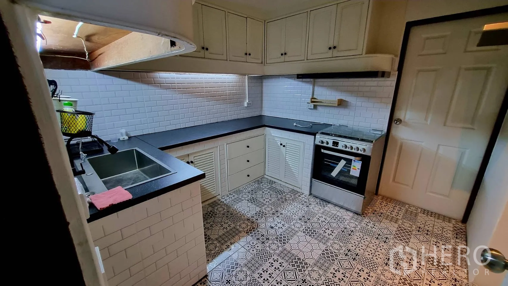 公寓 出租在Watthana, Bangkok - U形厨房，地铁砖墙、花纹地砖与燃气炉。