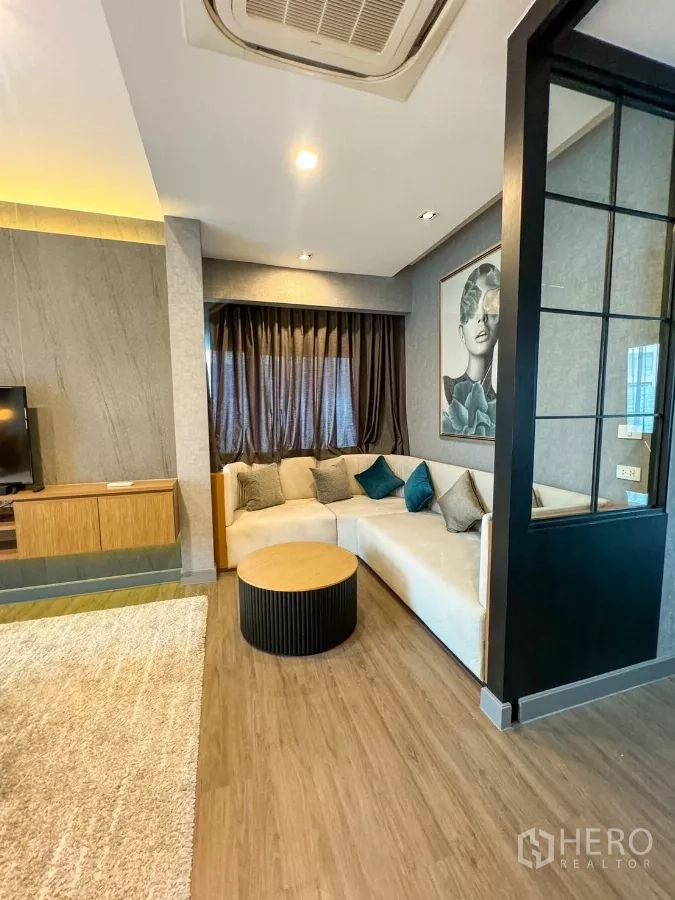 Detached House for rent or sale in Bueng Kum, Bangkok - Cozy corner lounge with L-shaped sofa, round coffee table and wood flooring.