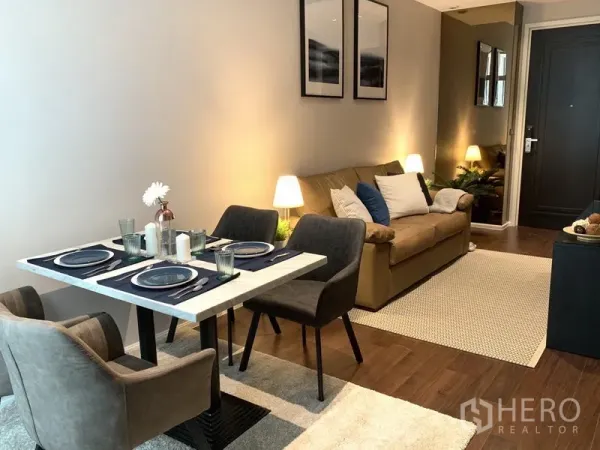 คอนโด ให้เช่าในWatthana, Bangkok - โซนรับแขกและรับประทานอาหารแบบโอเพ่น พร้อมโต๊ะ 4 ที่นั่ง โซฟา และแสงไฟอบอุ่น