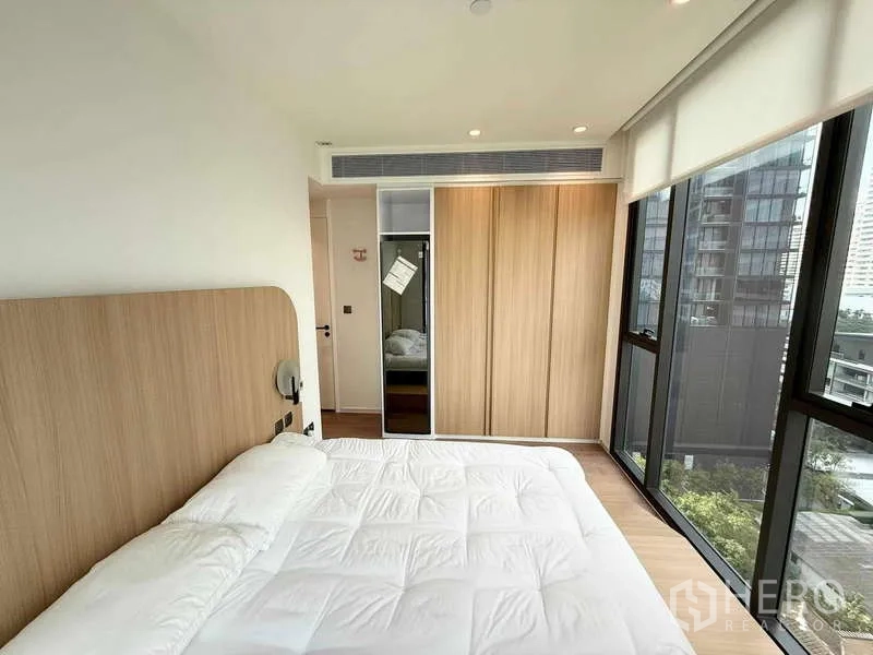 Condominium for rent in Watthana, Bangkok - Bedroom with built-in wardrobe, full-height windows, and soft recessed lighting.