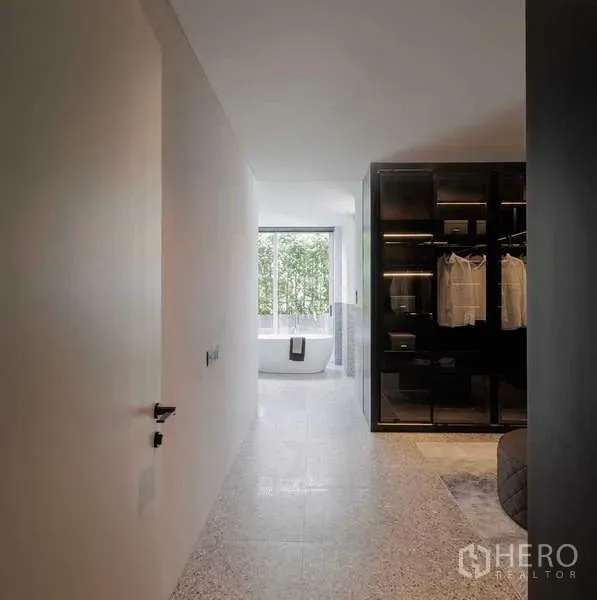 Home Office for rent in Bang Phli, Samut Prakan - Hallway leading to a bathroom with a freestanding tub and a walk-in wardrobe beside a large window.
