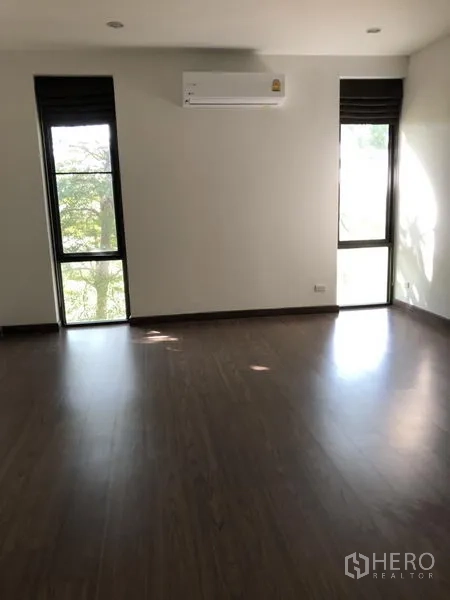 独立式住宅 出租在Prawet, Bangkok - 卧室铺木地板，两扇高窗，壁挂空调。