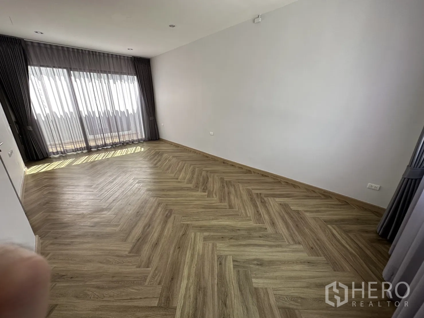 带办公室的家 出租或出售在Suan Luang, Bangkok - 宽敞卧室，鱼骨纹地板，推拉玻璃门通向阳台。