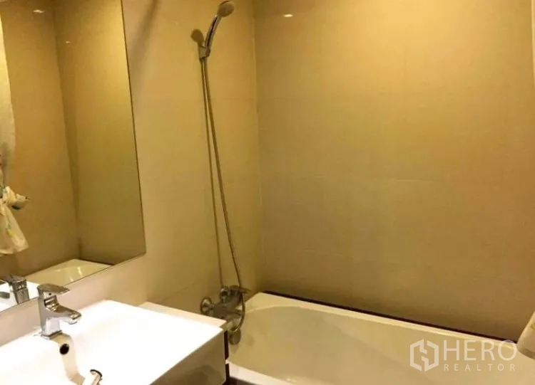 คอนโด ให้เช่าในKhlong Toei, Bangkok - ห้องน้ำพร้อมอ่างอาบน้ำและฝักบัวข้างอ่างล้างหน้าโทนขาว