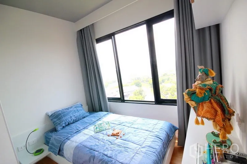 公寓 出租在Watthana, Bangkok - 次卧配单人床与大窗，可见城市与绿意景观