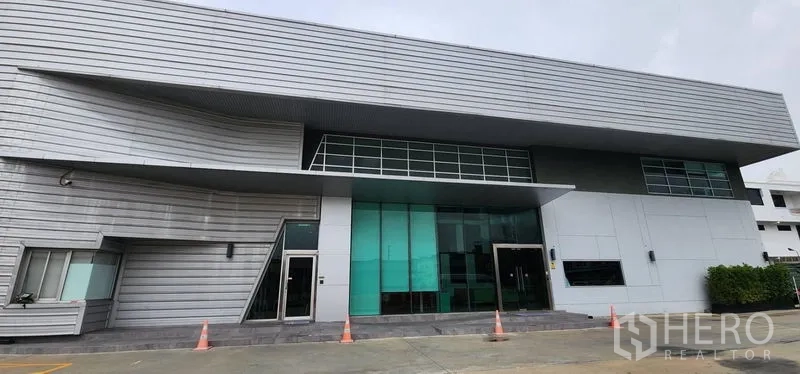Warehouse for rent in Bang Sue, Bangkok - Front elevation of the warehouse office building with large windows and entry steps.