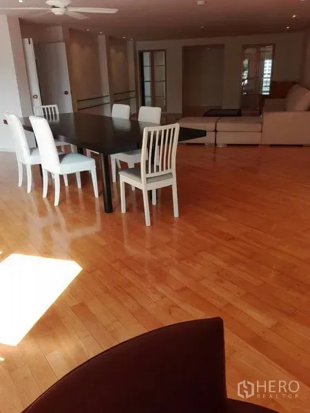 คอนโด ให้เช่าในKhlong Toei, Bangkok - มุมรับประทานอาหารโต๊ะยาวกับเก้าอี้สีขาว ในพื้นที่นั่งเล่นโปร่งพร้อมพัดลมเพดาน