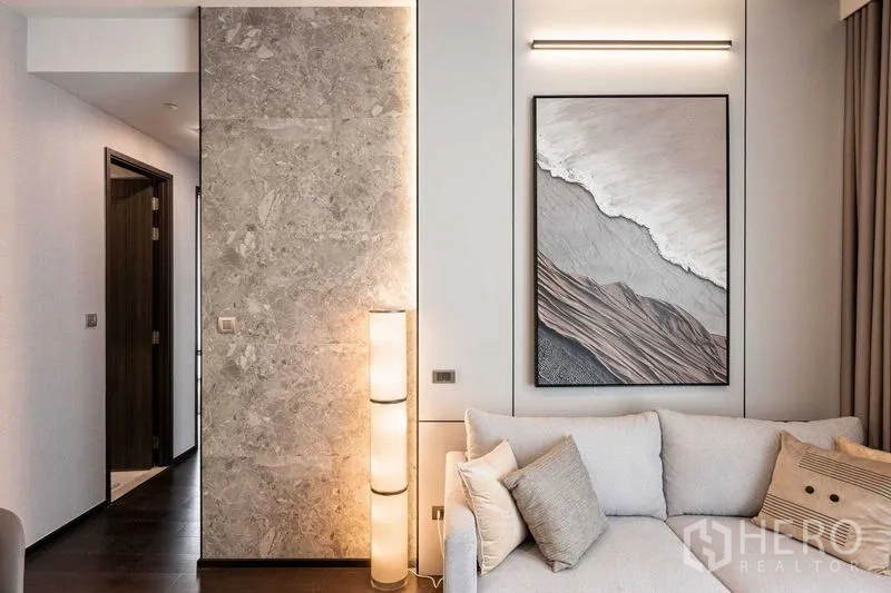 คอนโด ให้เช่าในWatthana, Bangkok - มุมนั่งเล่นอบอุ่น ผนังหินตกแต่ง โคมไฟตั้งพื้น และภาพกรอบ