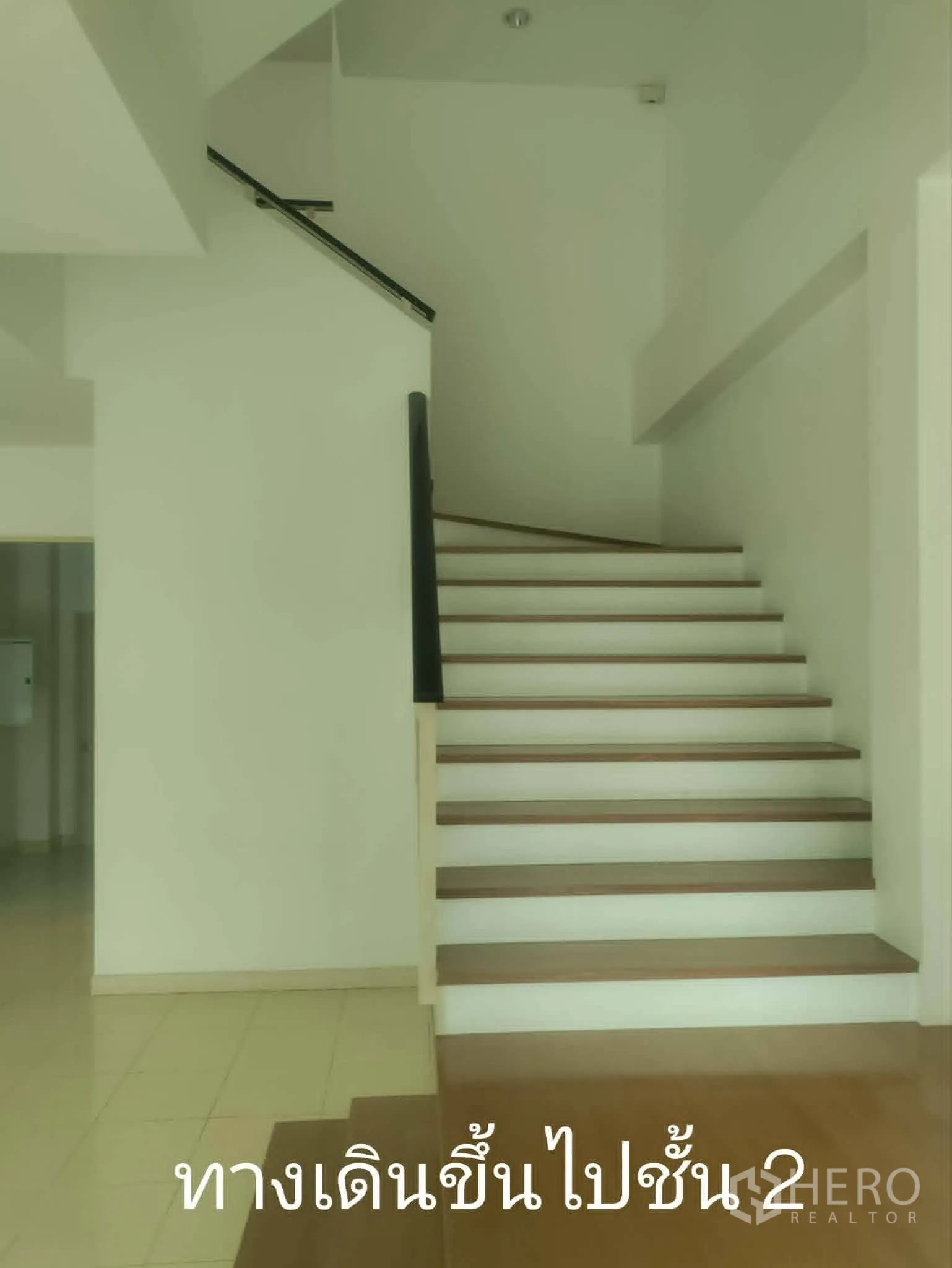 Home Office for rent in Lat Phrao, Bangkok - Staircase with dark handrail leading to upper level.