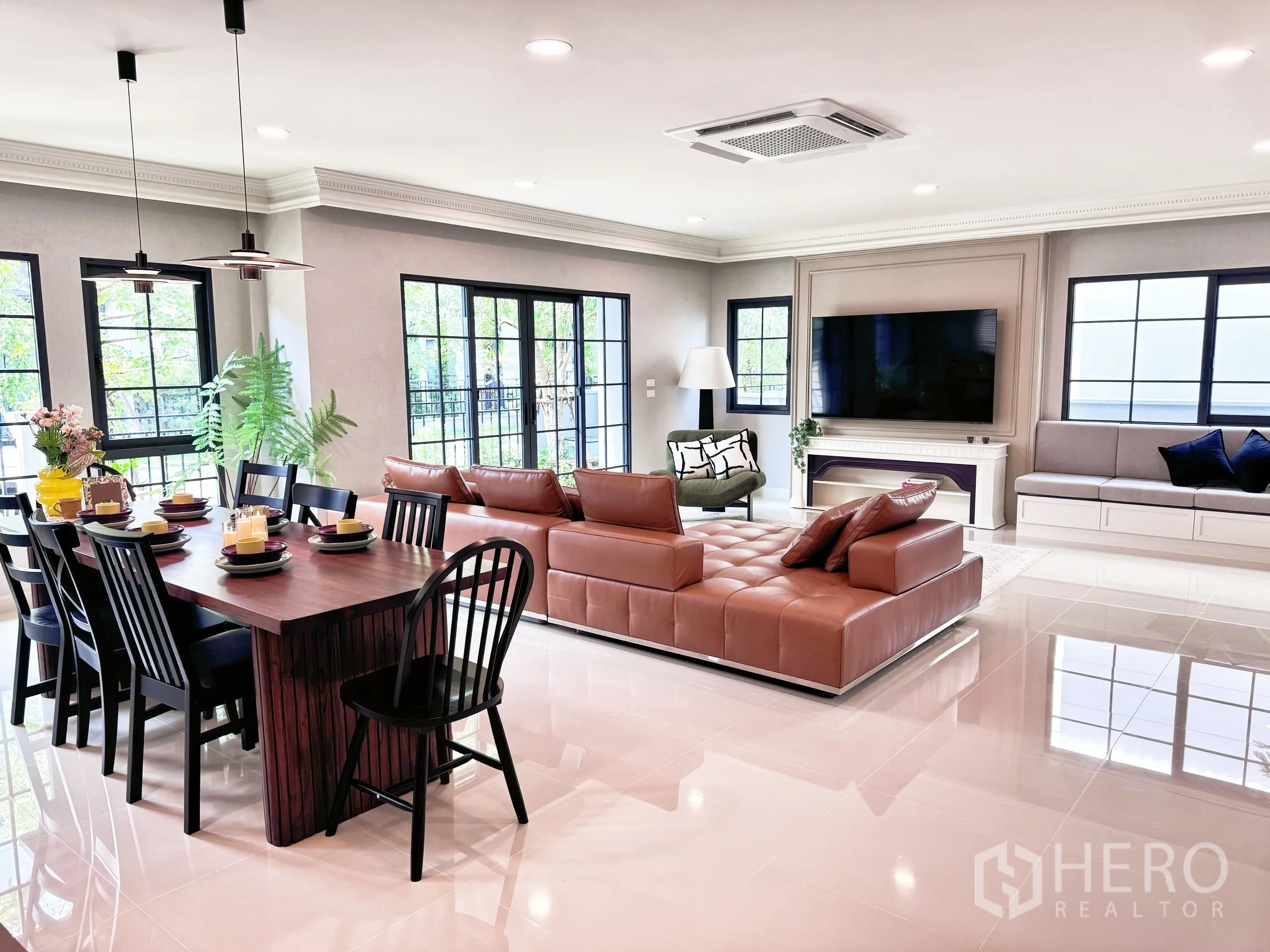 Detached House for rent in Bang Phli, Samut Prakan - Wide view of dining table, sofa, and media wall in a bright open-plan space.