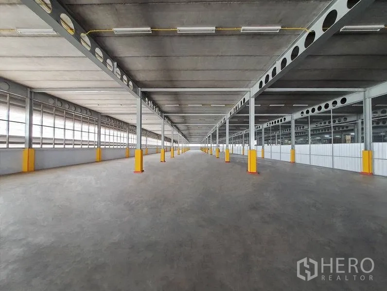 คลังสินค้า ให้เช่าในSi Maha Phot, Prachin Buri - ลานขนถ่ายสินค้าใต้หลังคาที่ยาว พื้นคอนกรีต เสาเหล็ก พร้อมกันชนสีเหลือง