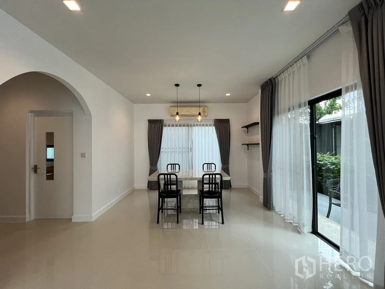 独立式住宅 出租在Bang Kapi, Bangkok - 餐厅摆放大理石餐桌与椅子，旁边是通向露台的移门。