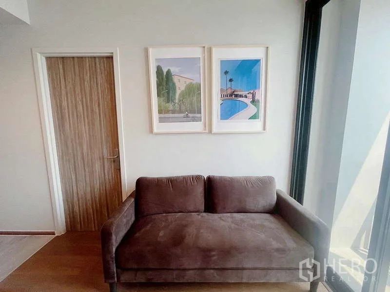 คอนโด ให้เช่าในKhlong Toei, Bangkok - โซฟาสีน้ำตาลสุดอบอุ่น ใต้กรอบภาพ ติดหน้าต่างกระจกเต็มสูง