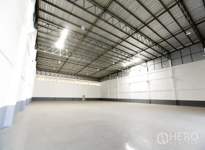 Factory for rent or sale in Bang Phli, Samut Prakan - Spacious warehouse interior with 8–11 m clear height, steel truss roof and polished concrete floor.