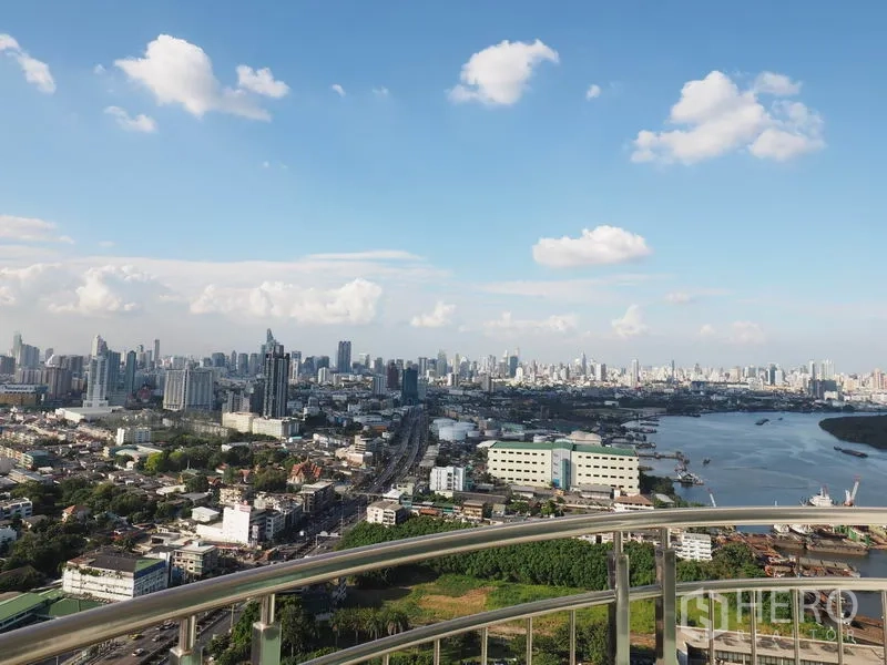 Condominium for rent in Yan Nawa, Bangkok - Panoramic skyline and river-bend view from the condo’s curved balcony railing in Yan Nawa.