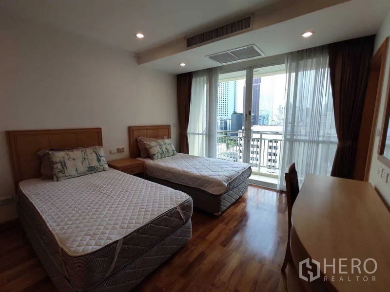 คอนโด ให้เช่าในKhlong Toei, Bangkok - ห้องนอนสว่างพร้อมเตียงเดี่ยวสองเตียง พื้นไม้ และระเบียงมองเห็นวิวเมืองผ่านกระจกบานใหญ่