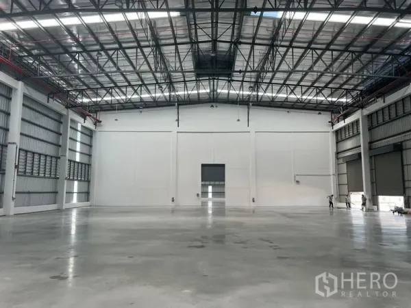 工厂 出租在Bang Pakong, Chachoengsao - 仓库内部开阔，抛光混凝土地面，高挑钢结构屋顶与天窗。