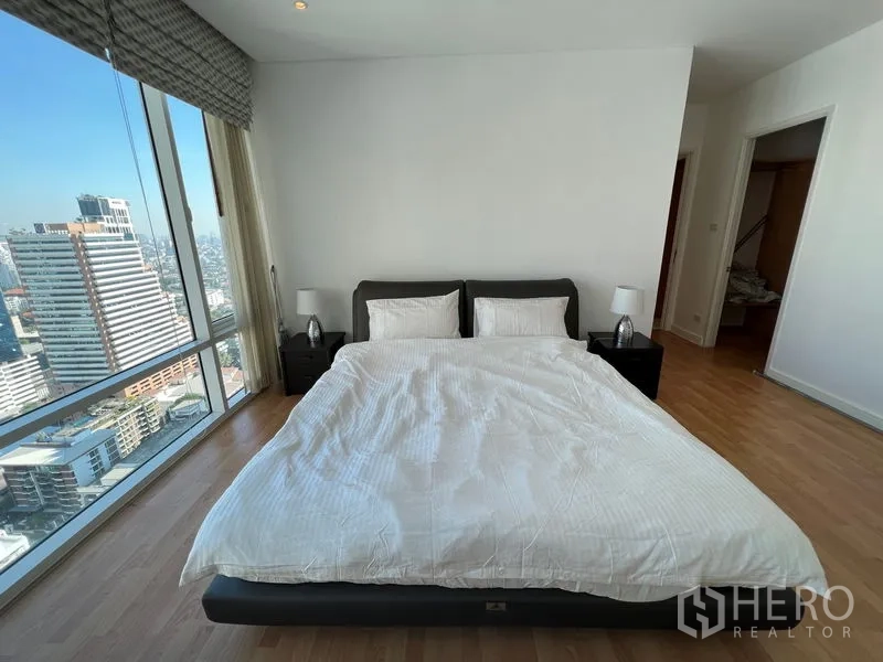 คอนโด ให้เช่าหรือขายในWatthana, Bangkok - ห้องนอนหลัก เตียงใหญ่ โต๊ะข้างเตียง และหน้าต่างสูงจรดเพดานชมวิวเมือง