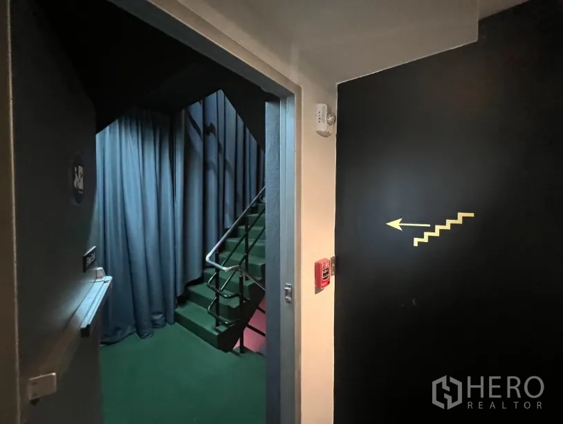 Retail Space for rent - Internal stairwell and fire-exit corridor with a directional arrow.