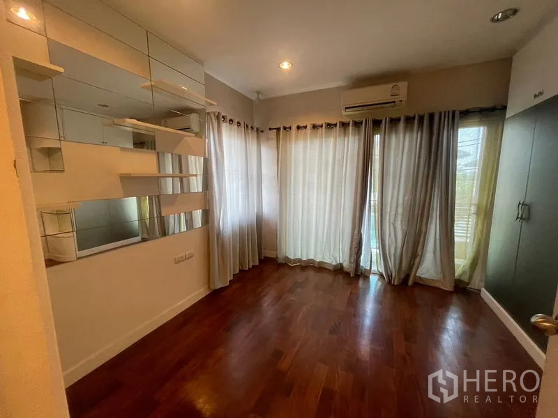 บ้าน ให้เช่าหรือขายในKhan Na Yao, Bangkok - ห้องนอนมุมบ้าน มีชั้นกระจก ผ้าม่านสูงจรดเพดาน และเครื่องปรับอากาศ