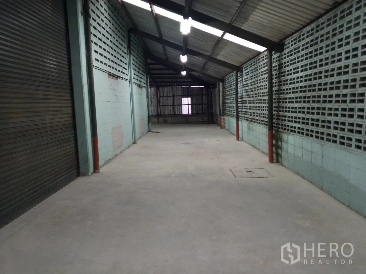 Warehouse for rent in Min Buri, Bangkok - Extended internal loading lane with vent block walls, overhead lights and shuttered openings.