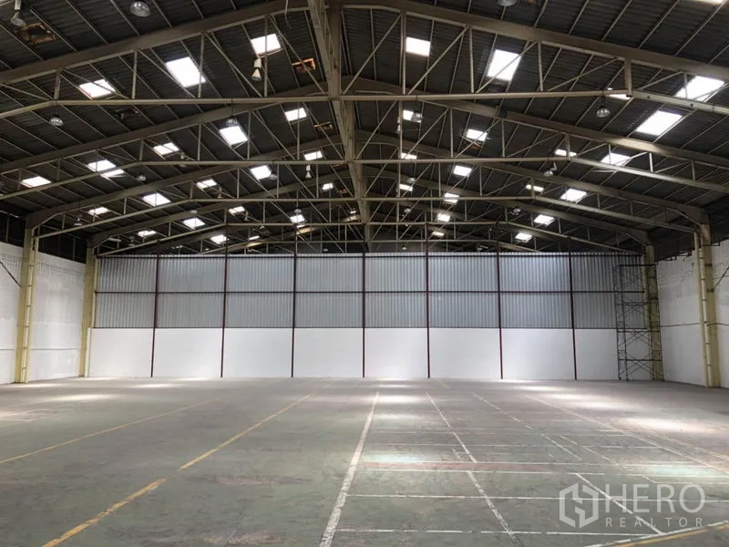 คลังสินค้า ให้เช่าในMueang Samut Prakan, Samut Prakan - ผนังท้ายโกดังกรุเมทัลชีท มีช่องแสง เพดานสูง และพื้นโล่ง.