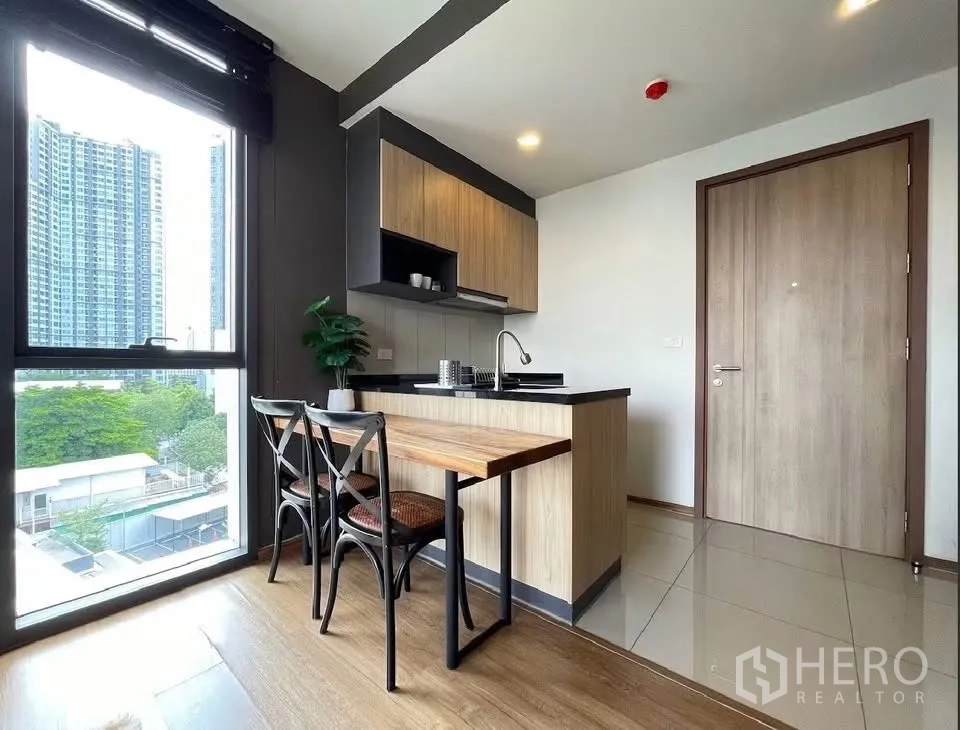 คอนโด for rent in Watthana, Bangkok - ครัวแบบเปิดตู้ไม้พร้อมโต๊ะทานอาหารและหน้าต่างบานใหญ่เห็นวิวเมือง